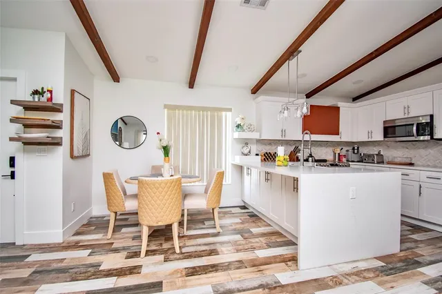 a kitchen with stainless steel appliances kitchen island granite countertop a stove a sink and a refrigerator