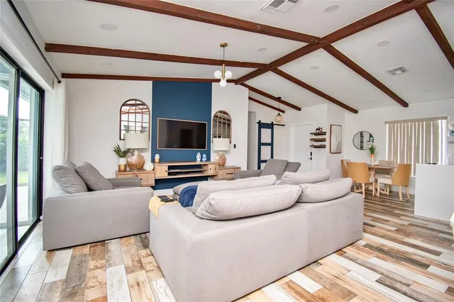 a living room with furniture a flat screen tv and a large window
