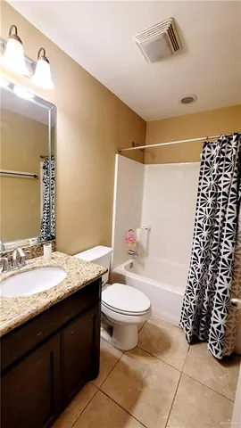 a bathroom with a granite countertop sink mirror vanity and toilet