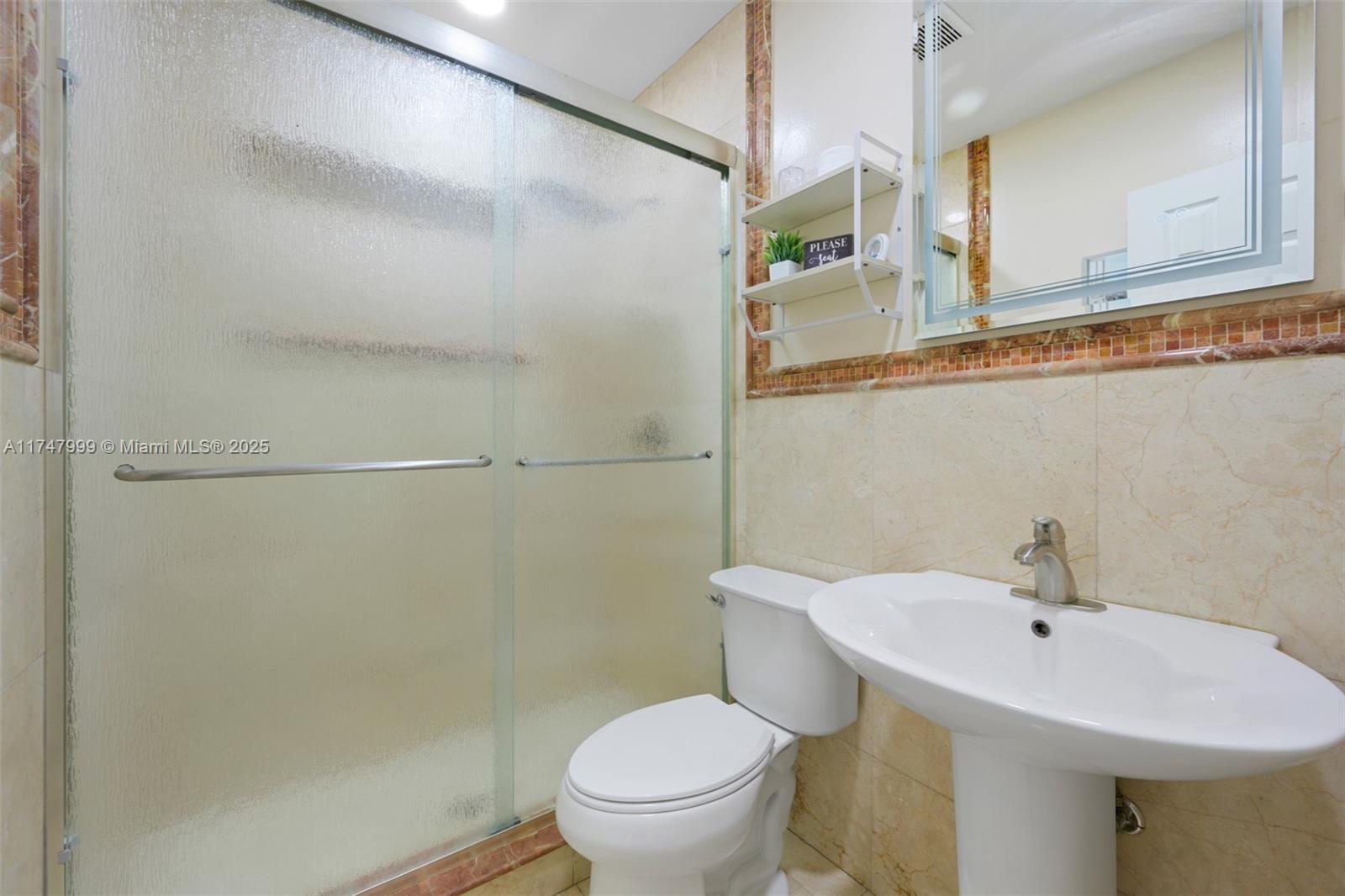 951 Northwest 148th Street Miami, FL 33168 - Photo 22 of 36 a bathroom with a sink a toilet and a mirror