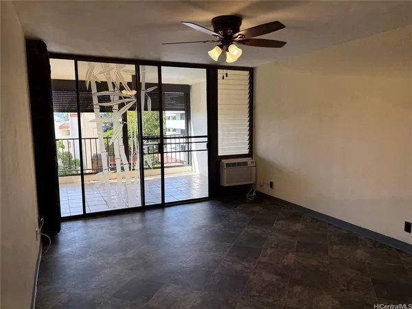 a view of empty room with wooden floor and fan