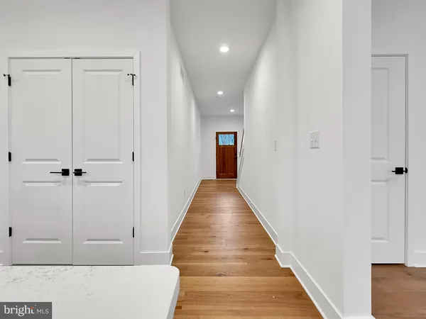 a view of a hallway with wooden floor and staircase