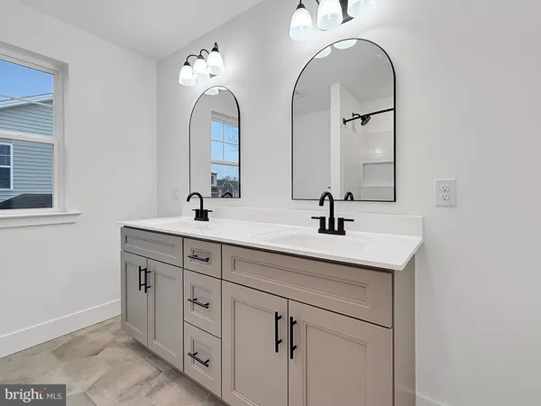 a bathroom with double vanity sinks and a mirror