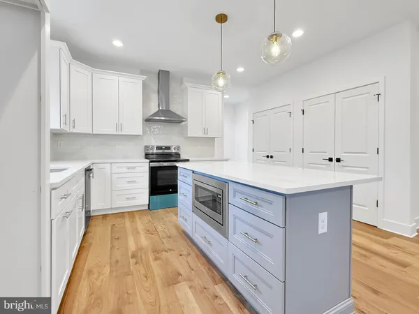 a kitchen with stainless steel appliances sink cabinets and wooden floor