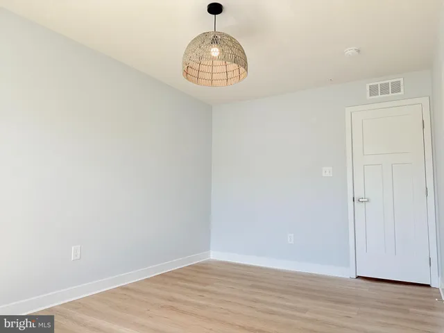 a view of empty room with wooden floor and entryway