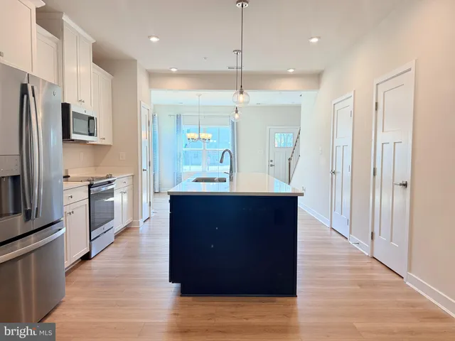a kitchen with kitchen island a counter top space stainless steel appliances and cabinets