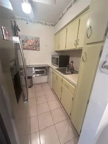 a kitchen with a sink a refrigerator and cabinets