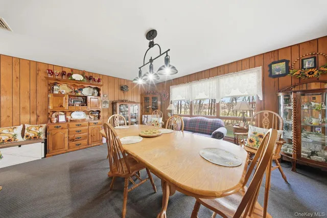 a dining room with furniture a chandelier and wooden floor
