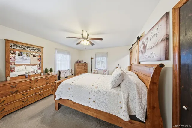 a spacious bedroom with a bed and dresser with mirror