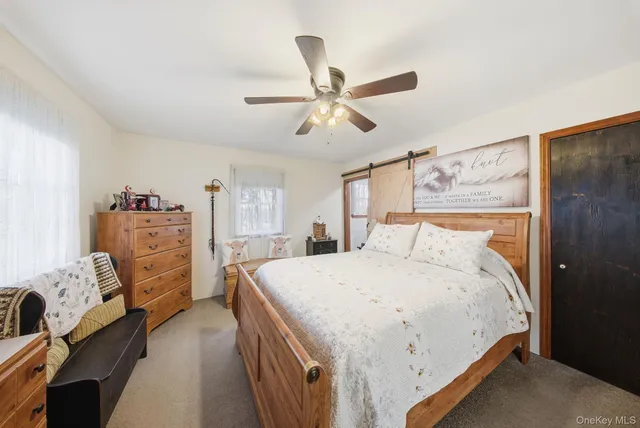 a bedroom with a bed and dresser with wooden floor