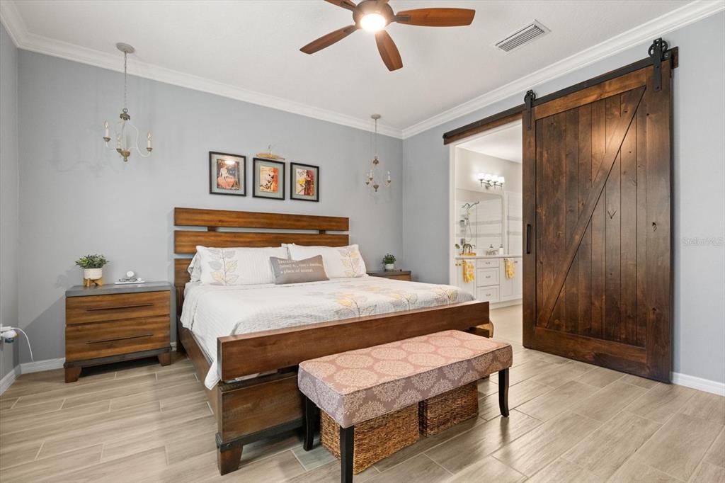 100 Silver Maple Road Groveland, FL 34736 - Photo 12 of 54 a bedroom with a bed and a chandelier