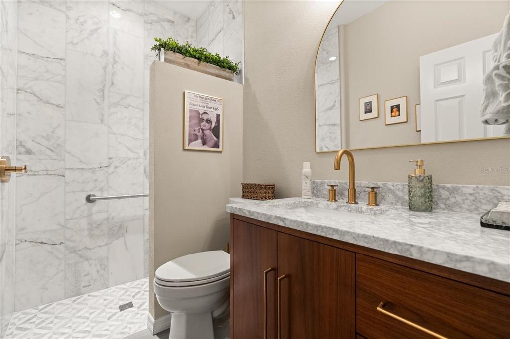 100 Silver Maple Road Groveland, FL 34736 - Photo 17 of 54 a bathroom with a granite countertop toilet sink and mirror