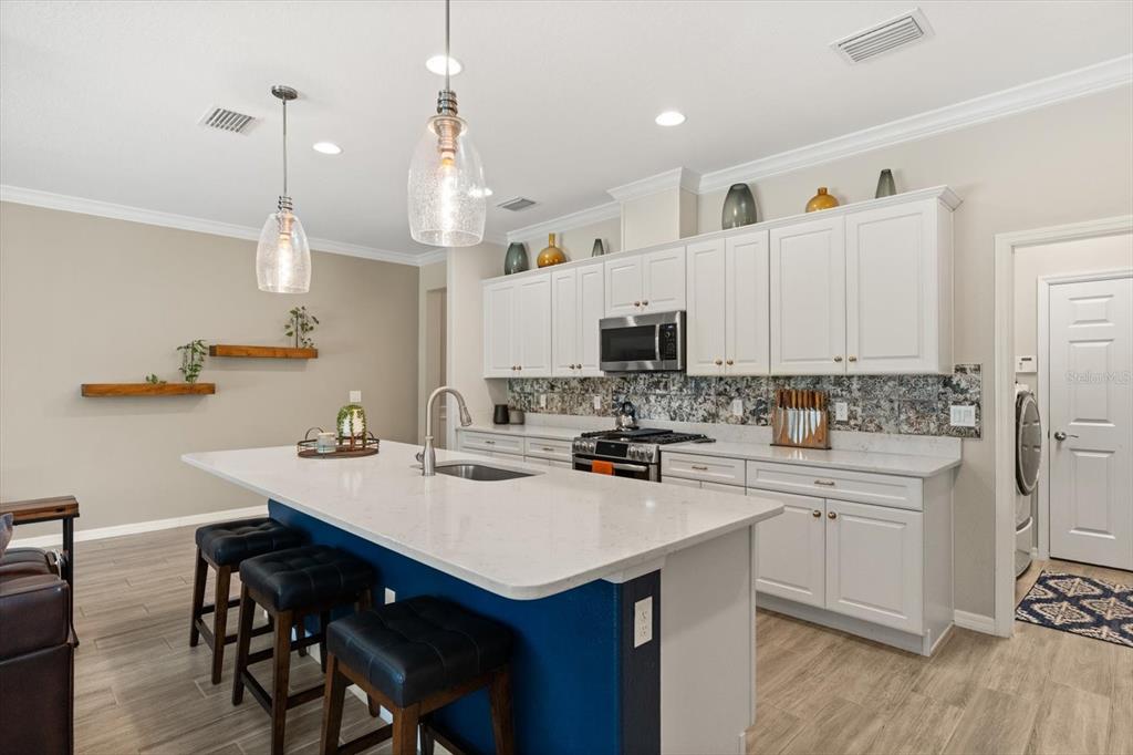 100 Silver Maple Road Groveland, FL 34736 - Photo 5 of 54 a kitchen with a sink a stove cabinets and wooden floor