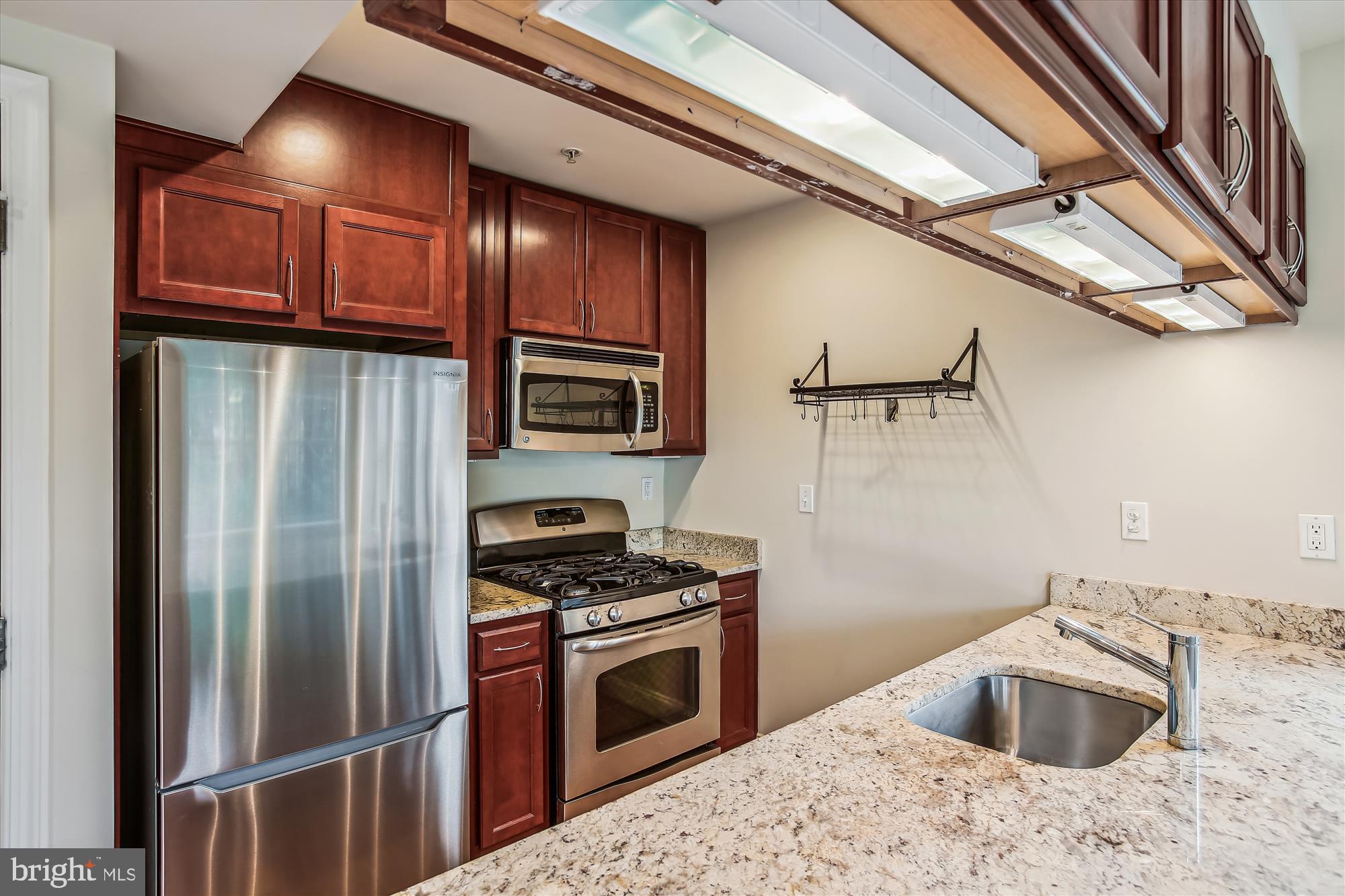 922 Madison Street Northwest, Unit 201 Washington, DC 20011 - Photo 10 of 34 a kitchen with stainless steel appliances kitchen island granite countertop a refrigerator sink and stove