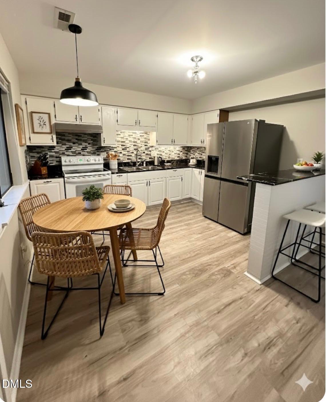 322 Junction Road, Unit 28H Durham, NC 27703 - Photo 6 of 18 a kitchen with stainless steel appliances granite countertop a stove a refrigerator a kitchen island a stove a dining table and chairs