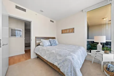 a bedroom with bed and a table with potted plant