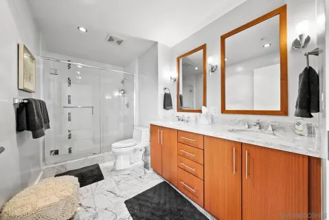 a bathroom with a double vanity sink toilet and shower