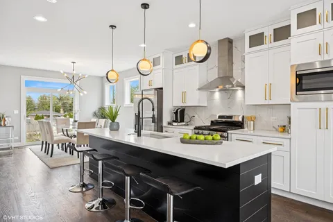a kitchen with a sink a stove and chairs
