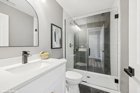 a bathroom with a sink a toilet and shower