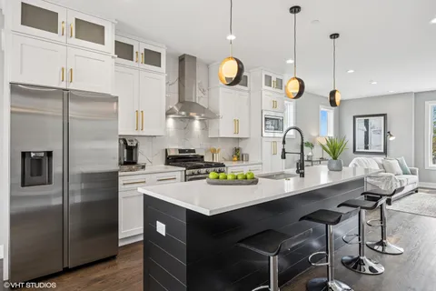 a kitchen with a sink stainless steel appliances and chandelier
