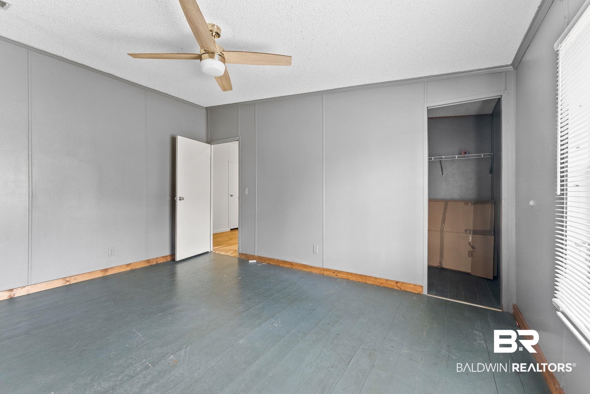34904 Pine Road South Stapleton, AL 36578 - Photo 21 of 42 Unfurnished bedroom with ceiling fan, a decorative wall, dark wood finished floors, and a textured ceiling