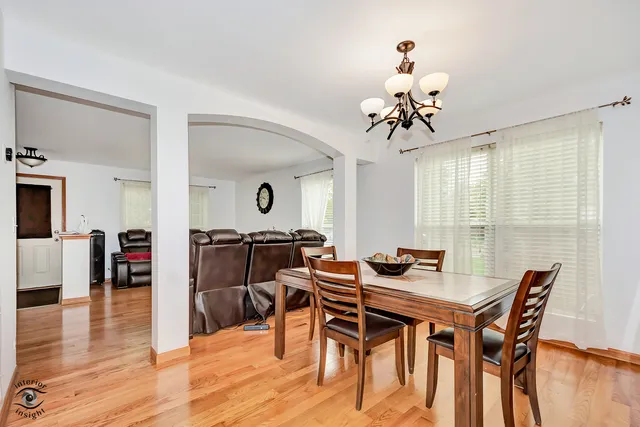 a dining room with furniture a chandelier and wooden floor