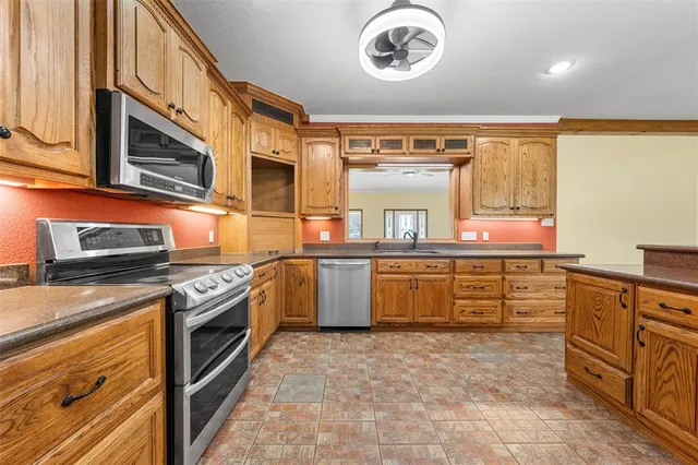 a kitchen with stainless steel appliances granite countertop a stove a sink and a microwave