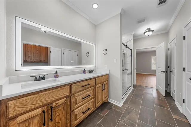 a spacious bathroom with a double vanity sink a mirror and a shower