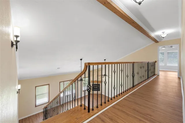a view of a hallway with wooden floor and staircase