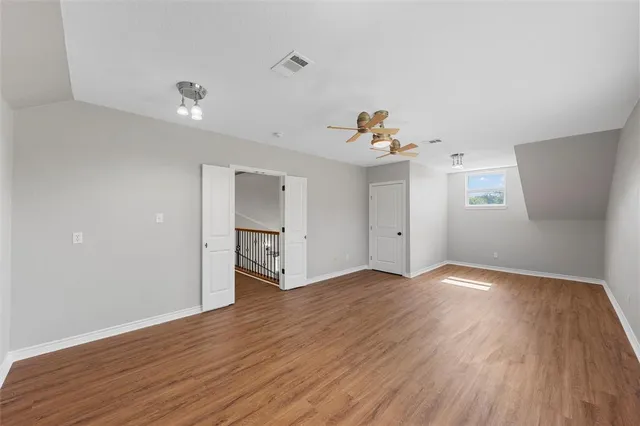 an empty room with wooden floor and natural light