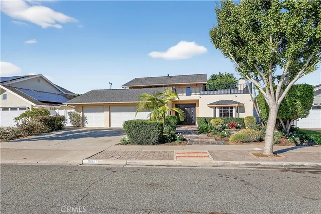 a front view of a house with a yard and potted plants