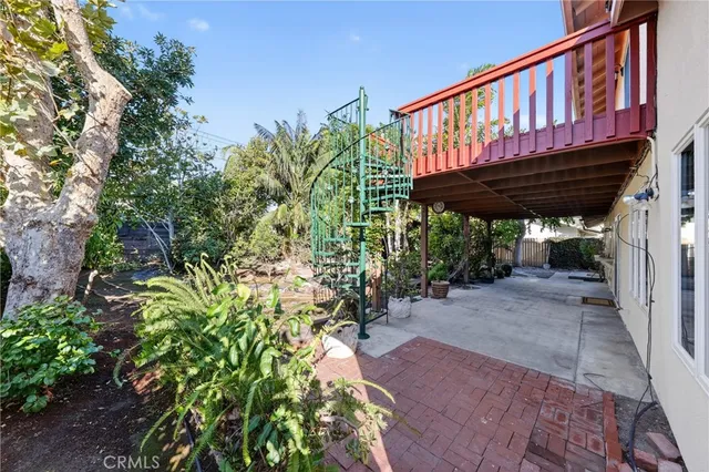 a view of a patio with a table and chairs under an umbrella with potted plants