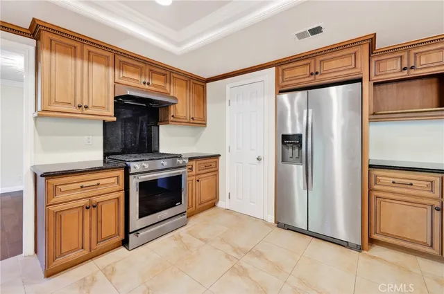 a kitchen with stainless steel appliances granite countertop a refrigerator stove and sink