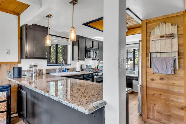 a kitchen with stainless steel appliances granite countertop a sink stove and cabinets
