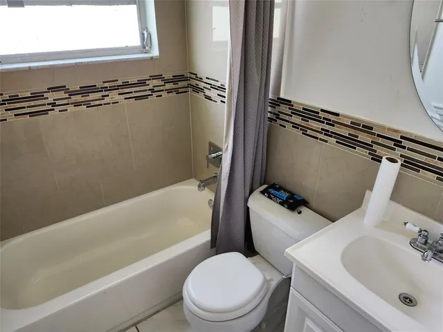 a bathroom with a tub a window and a shower