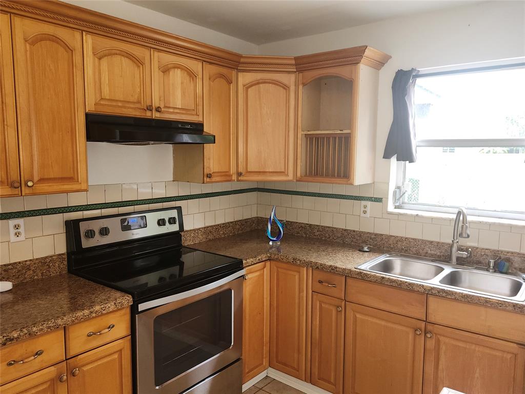 10720 Eureka Street Boca Raton, FL 33428 - Photo 8 of 18 a kitchen with granite countertop a sink stove and cabinets