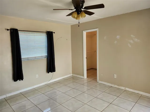 an empty room with windows and cabinet