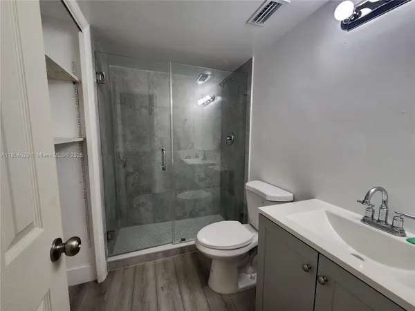 a bathroom with a shower a toilet and a sink
