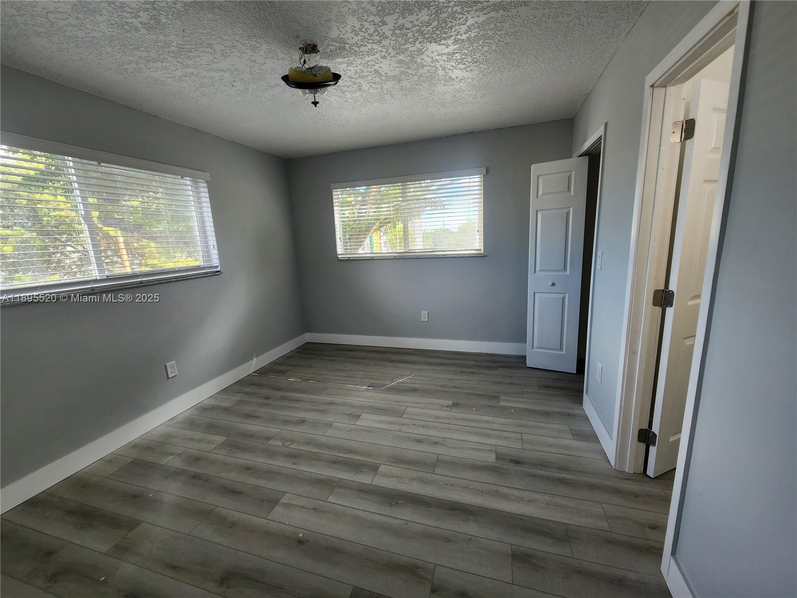 11309 Southwest 200th Street, Unit 303C Miami, FL 33157 - Photo 7 of 21 an empty room with wooden floor and windows
