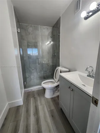 a bathroom with a sink a toilet a mirror and shower