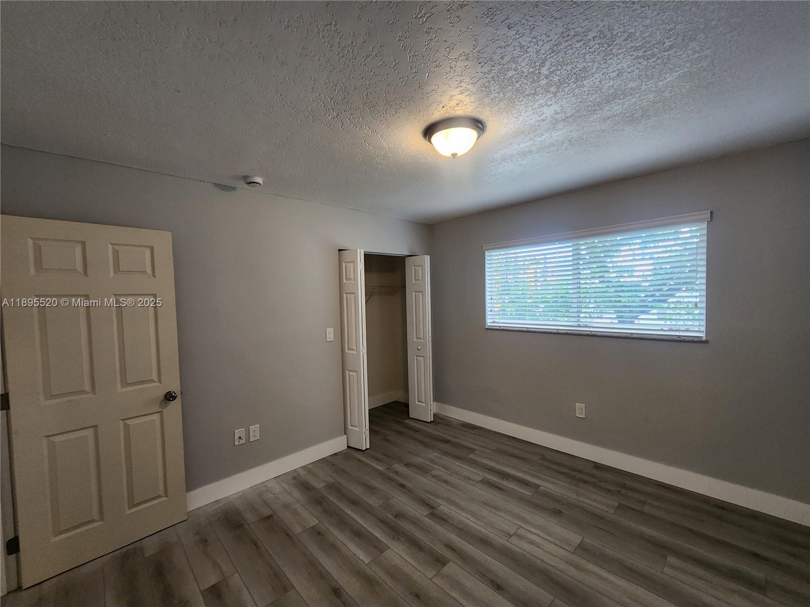 11309 Southwest 200th Street, Unit 303C Miami, FL 33157 - Photo 9 of 21 an empty room with wooden floor and windows