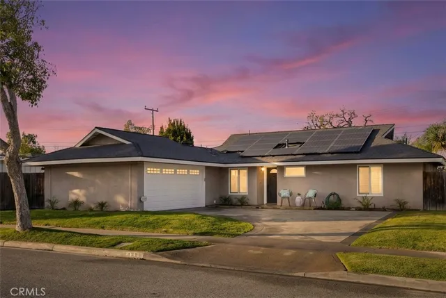a front view of a house with a garden and a garage