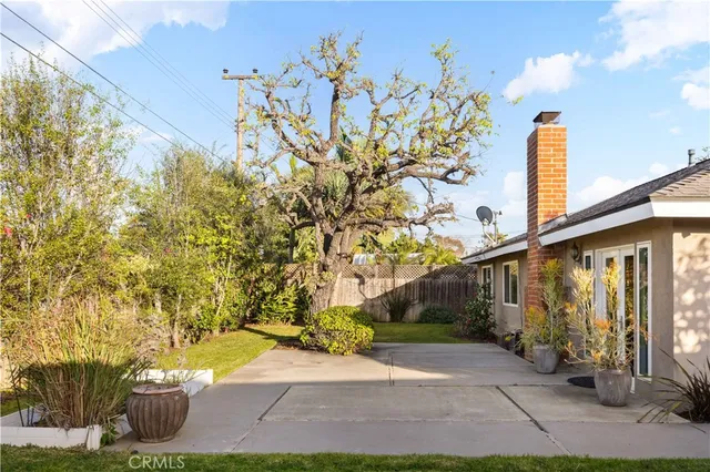 a front view of a house with a yard and potted plants