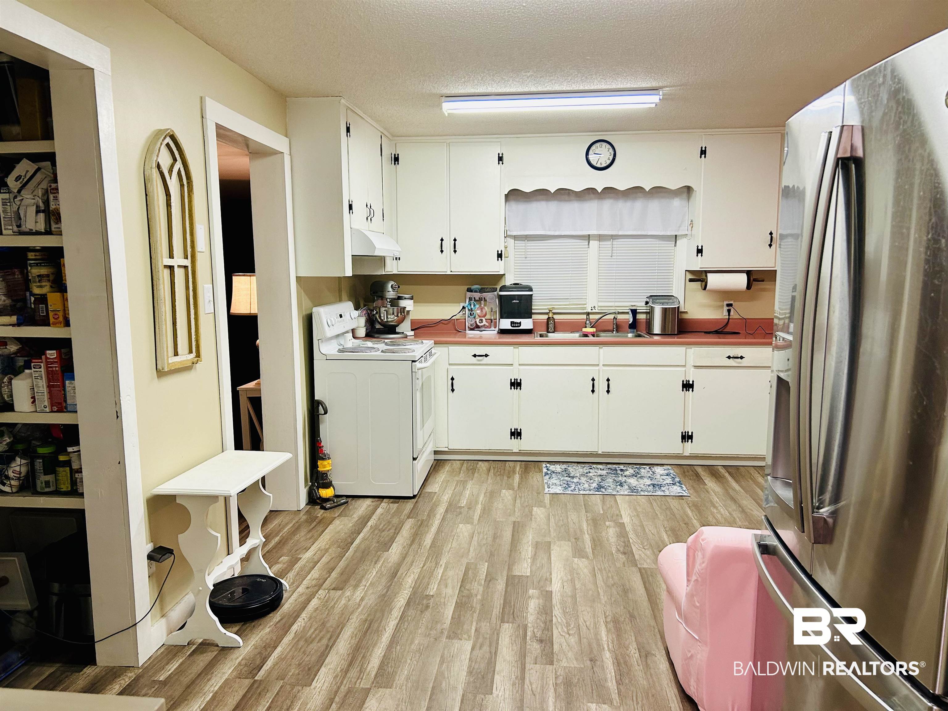 3850 Newman Road Mobile, AL 36695 - Photo 12 of 27 Kitchen featuring a textured ceiling, white range oven, stainless steel refrigerator, and white cabinetry