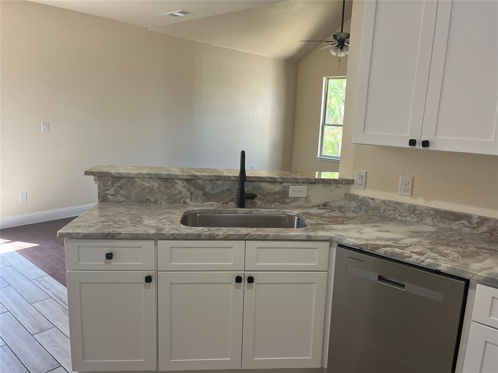5332 Booker T Street Fort Worth, TX 76105 - Photo 4 of 18 a kitchen with granite countertop cabinets sink and window
