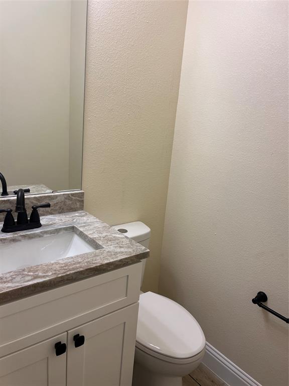 5332 Booker T Street Fort Worth, TX 76105 - Photo 6 of 18 a bathroom with a granite countertop toilet and a sink