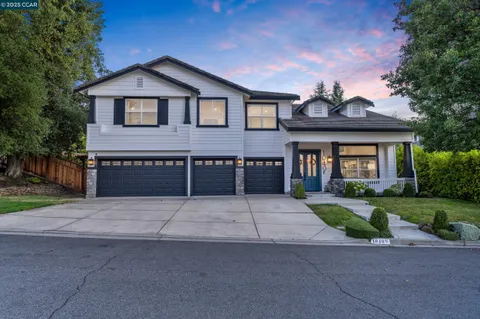 a front view of a house with a garden and trees