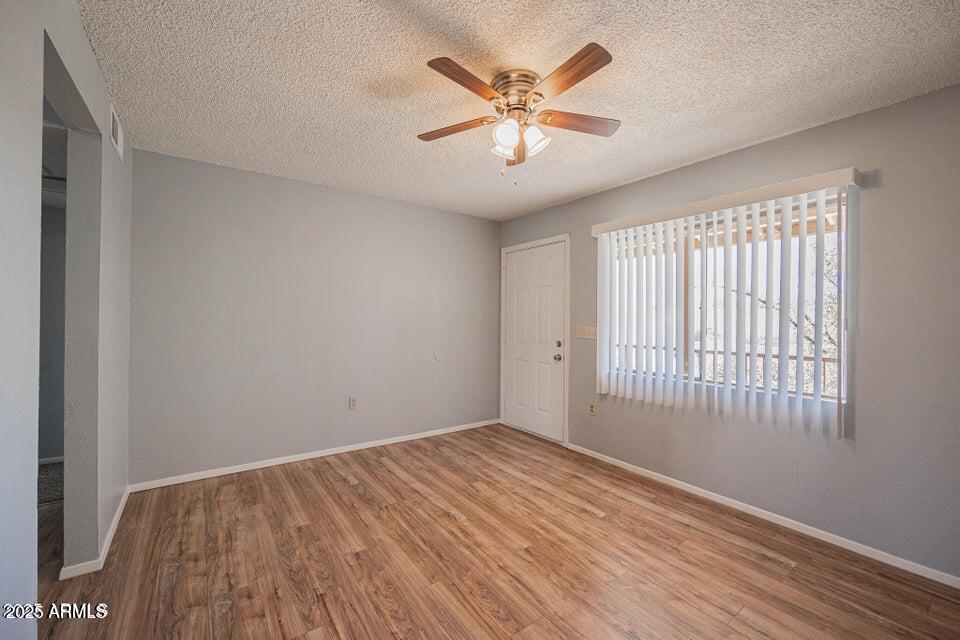 127 South Outpost Road, Unit 4 Apache Junction, AZ 85119 - Photo 2 of 8 an empty room with wooden floor and windows
