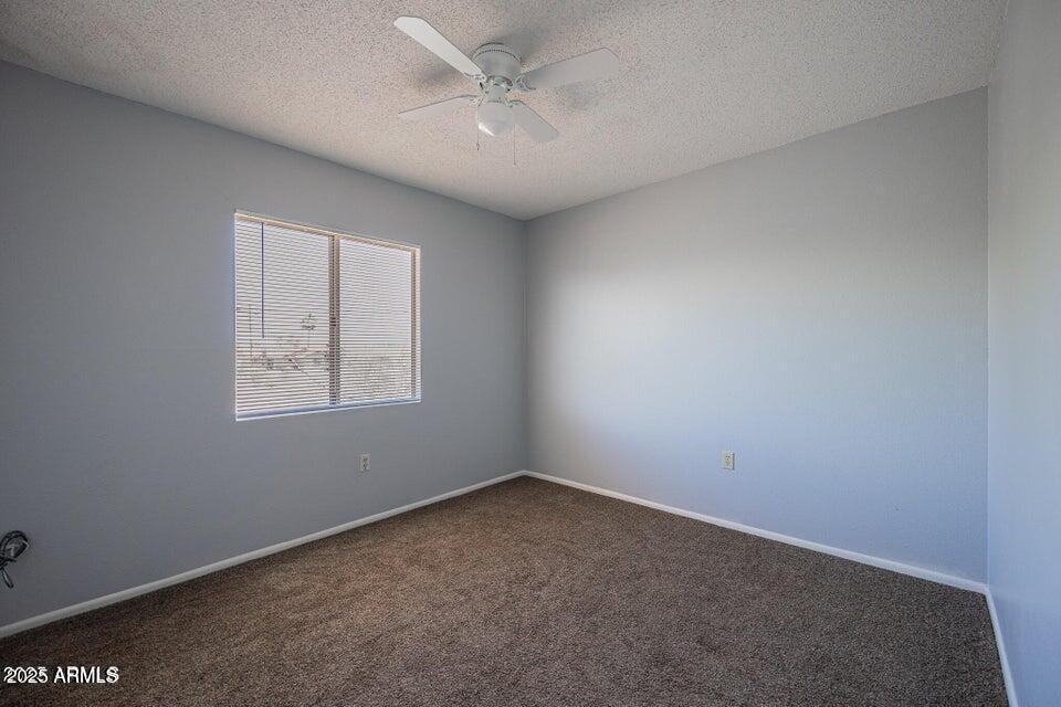 127 South Outpost Road, Unit 4 Apache Junction, AZ 85119 - Photo 5 of 8 an empty room with a window and ceiling fan