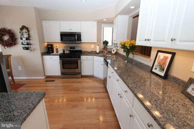 1330 Wedgewood Manor Way Reston, VA 20194 - Photo 3 of 30 a large kitchen with granite countertop a stove a sink and a microwave